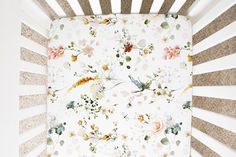 a white crib with flowers and birds on it