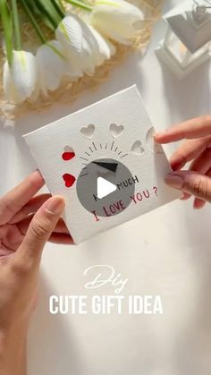 two hands holding a card that says i love you