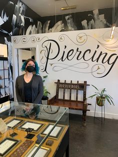 a woman wearing a face mask standing in front of a display case