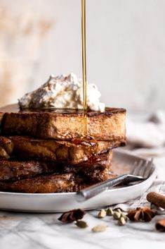 toasted french toast with whipped cream and syrup being drizzled on top