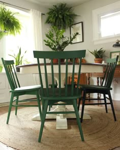 three green chairs sitting on top of a rug in front of a potted plant