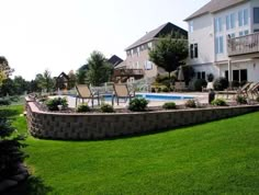 a large backyard with a pool and lawn furniture in the foreground, surrounded by houses