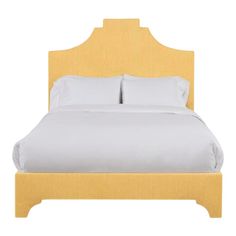 a bed with white sheets and yellow headboard