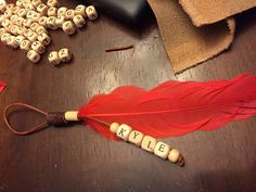 a red feather and some letters on a table