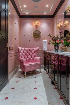 a pink chair sits in the middle of a room with gold trimmings on the walls