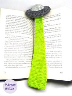 an open book with a crocheted tie and hat on it