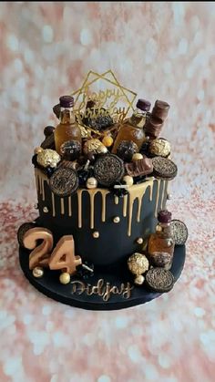 a birthday cake with chocolate, cookies and decorations on it's tiered black icing