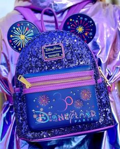 a purple backpack with mickey mouse ears and fireworks on the front is shown in this image