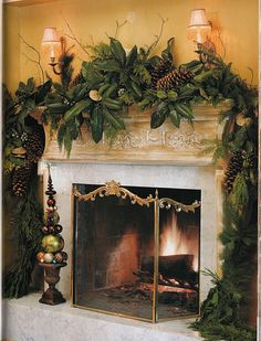 a fireplace decorated for christmas with pine cones and greenery