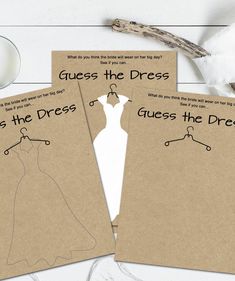 three brown paper cards with clothes on hangers next to cotton floss and scissors