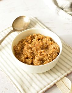 a bowl filled with oatmeal sitting on top of a white place mat