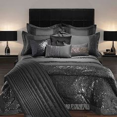 a black and silver bed with sequins on the comforter, pillows and lamps