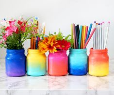 colorful mason jars filled with pencils and flowers