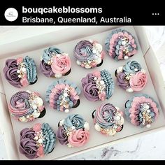 twelve cupcakes in a box decorated with flowers and pearls