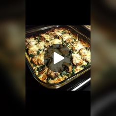 a casserole dish with chicken and spinach in it on a black background