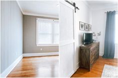 an empty living room with wood floors and white walls