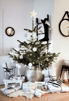 a small christmas tree in a room with white and black ornaments on the floor,