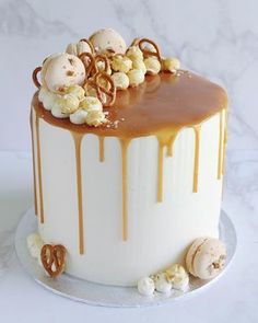 a white cake with caramel drizzled on top and candies all over it