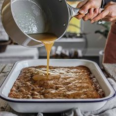 someone pouring sauce into a casserole dish