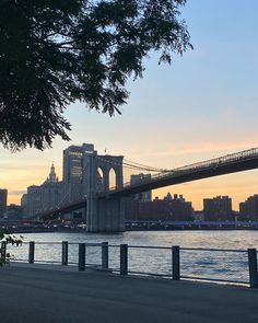 the brooklyn bridge at sunset as seen from across the river