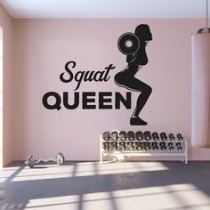 there is a gym room with pink walls and black lettering on the wall that says squat queen