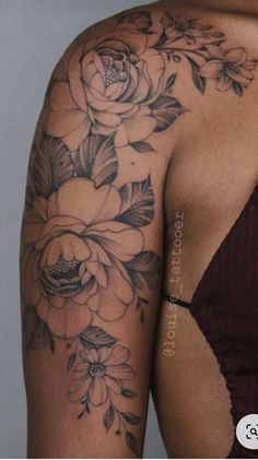 a woman's arm with flowers on it and the back of her body covered in tattoos