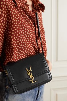 SAINT LAURENT's bag has a sleek profile that spotlights the gold 'YSL' plaque at the front. There's a slot inside for cards and a concealed front pocket that's perfect for keeping your lipstick close to hand. The small size means you can carry it day or night.  Wear it with: [SAINT LAURENT Shirt id1265085], [SAINT LAURENT Jeans id1265092]. Sac Yves Saint Laurent, Saint Laurent Shirt, Saint Laurent Jeans, Camel Blazer, Yves Saint Laurent Bags, Purse Brands, Elegante Casual, Best Handbags, Black Shoulder Bag