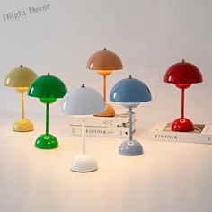 four different colored lamps sitting next to each other on top of a white countertop