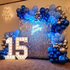 the number 15 is surrounded by balloons and streamers in front of a large sign