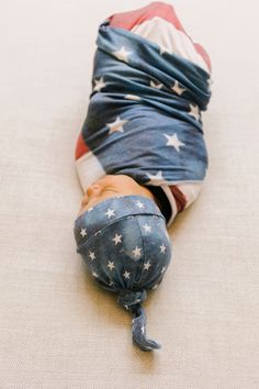 a baby wrapped in an american flag blanket