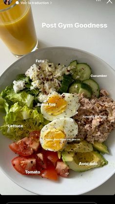 a white plate topped with salad next to a glass of orange juice