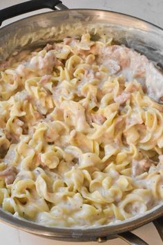 a pan filled with pasta and meat on top of a stove