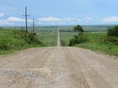 an empty dirt road in the middle of nowhere