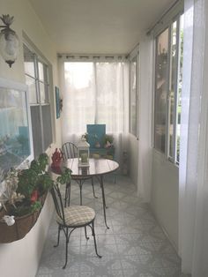 an empty room with two chairs and a table in the corner, next to a window