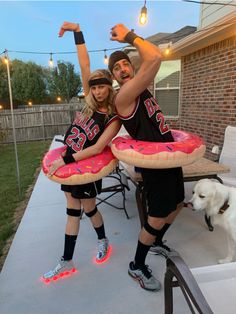 a man and woman are holding giant donuts