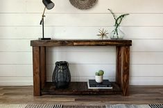 a wooden table sitting on top of a hard wood floor next to a wall mounted clock