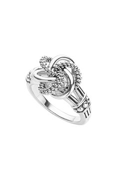 a white gold ring with diamonds on the sides and an openwork design in the middle