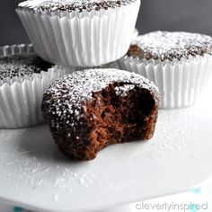 chocolate cupcakes with powdered sugar on top and one cut open to show the inside