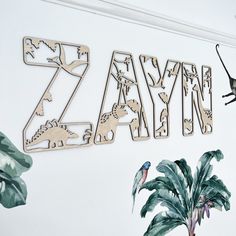 the letters and numbers are made out of wooden cutouts, with plants in front of them