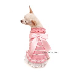 a small dog wearing a pink dress with a bow on it's neck and collar