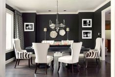 a black and white dining room with zebra print chairs, chandelier, and table