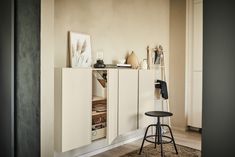 a white cabinet sitting next to a black stool