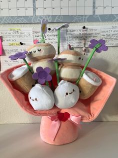 a pink vase filled with stuffed animals on top of a table