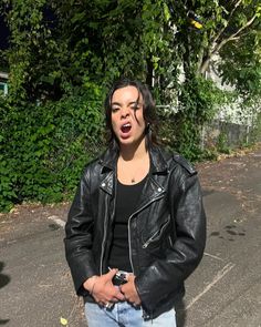 a woman standing in the middle of a parking lot with her mouth open and tongue out