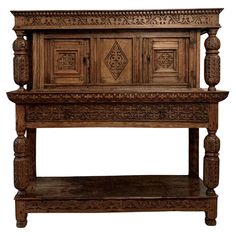 an old wooden table with carvings on the top and bottom shelf, in front of a white background