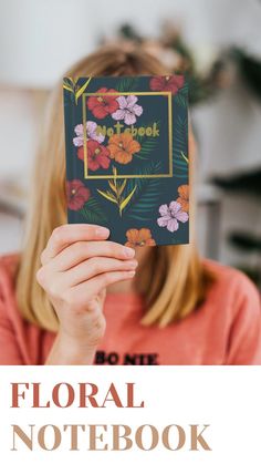 a woman holding up a floral notebook in front of her face with the words floral notebook written