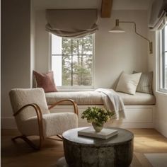 a living room filled with furniture and a window covered in draping next to a wooden coffee table