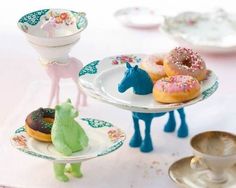 there are three plates that have donuts on them and one has a horse figurine