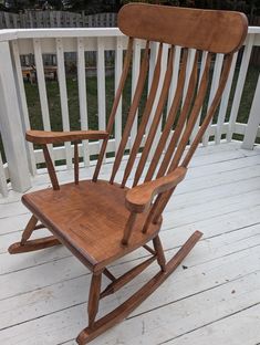 a wooden rocking chair sitting on top of a white deck