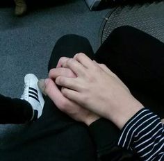 a person sitting on the floor holding their hands together